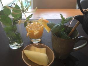 a table with a cup and a bowl of cheese and a plant at B&B Hip in Bruges