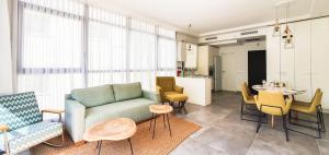a living room with a couch and chairs and a table at BnBIsrael apartments - Rupin Ruby in Tel Aviv