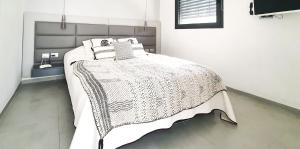 a bedroom with a bed with a white comforter at BnBIsrael apartments - Rupin Ruby in Tel Aviv