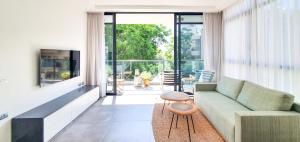 a living room with a couch and a large window at BnBIsrael apartments - Rupin Ruby in Tel Aviv