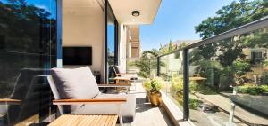 a balcony with two chairs and a television on it at BnBIsrael apartments - Rupin Ruby in Tel Aviv