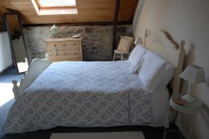 a bedroom with a bed and a dresser and a window at Le Moulin des Farges in Meymac