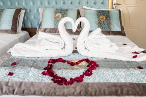 two swans are forming a heart on a bed at Istanbul Sirkeci Hotel in Istanbul