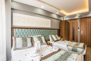 a bedroom with two beds and a green headboard at Istanbul Sirkeci Hotel in Istanbul