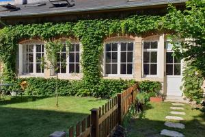 a house covered in ivy with a wooden fence at APPARTEMENT DE CHARME AU COEUR DE NEVERS in Nevers
