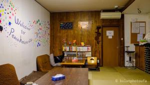 a room with a table and a wall with writing on it at Peace House Showa in Osaka