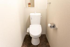 Un baño con un inodoro blanco en una cabina. en Nedoco Osaka West, en Osaka