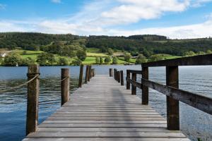 a wooden bridge over a body of water at The Coniston Inn - The Inn Collection Group in Coniston