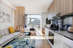 uma sala de estar com um sofá e uma cozinha em Backup-Powered Trendy NY City Apartment at Table Mountain em Cidade do Cabo