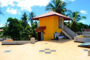 a small yellow house with a roof at Villa16Hikkaduwa in Hikkaduwa