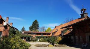 un grand bâtiment en briques avec une tour d'horloge. dans l'établissement Gemütliche, neu renovierte Einraum-FeWo auf dem Bauernhof, à Oetzen