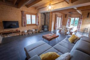 een grote woonkamer met een bank en een tafel bij Chalet Skadi in La Bresse