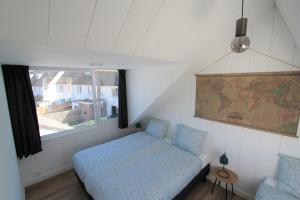 ein kleines Schlafzimmer mit einem Bett und einem Fenster in der Unterkunft Beaufort in Egmond aan Zee
