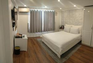 1 dormitorio con cama blanca y ventana en Galaxy Hotel, en Ho Chi Minh