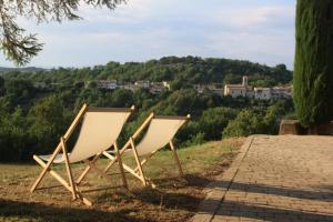 two white chairs sitting on the grass in a field at Les Demeures du Clos in Niozelles