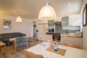 eine Küche und ein Wohnzimmer mit einem Tisch und Stühlen in der Unterkunft Gästehaus Heinemann - Eg5 in Langenargen