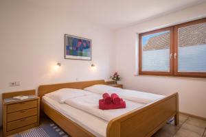 ein Schlafzimmer mit einem Bett mit zwei roten Schuhen darauf in der Unterkunft Gästehaus Heinemann - Eg5 in Langenargen