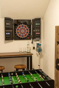 une chambre avec un jeu de fléchettes et une table dans l'établissement Ferienwohnung FUCHSBAU im EG des Ferienhauses Falkenhöhe, à Meuselbach-Schwarzmühle