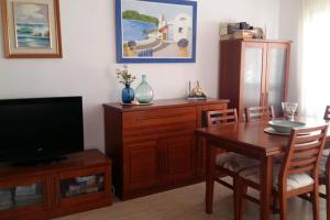 un soggiorno con tavolo da pranzo e TV di Apartamento familiar a orillas del Mar Menor a Los Alcázares