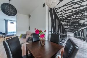 wazon kwiatów na drewnianym stole w salonie w obiekcie Dworzec Centralny P&O Serviced Apartments w Warszawie
