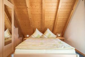 Bett in einem Zimmer mit Holzdecke in der Unterkunft Haus Sonnenschein in Eriskirch