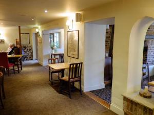 a dining room with a table and chairs and people sitting at tables at The Pelican Inn in Froxfield