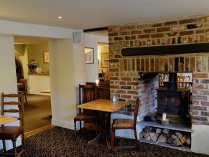 a dining room with a brick fireplace and a table at The Pelican Inn in Froxfield