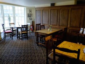 a dining room with two tables and chairs and a table at The Pelican Inn in Froxfield