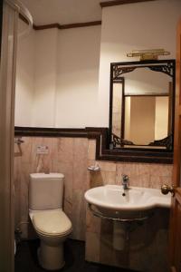 een badkamer met een toilet, een wastafel en een spiegel bij Max Residence in Pattaya