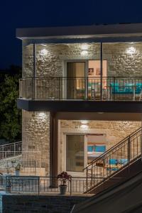 Casa de ladrillo con balcón por la noche en Efkosmias Apartments, en Pitsidia