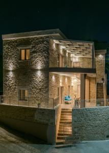 Casa de piedra con balcón por la noche en Efkosmias Apartments, en Pitsidia
