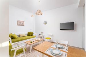a living room with a green couch and a table at Efkosmias Apartments in Pitsidia