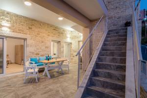 a dining room with a table and a brick wall at Efkosmias Apartments in Pitsidia