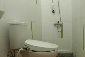 a white bathroom with a toilet and a shower at Omah Kebon Nitiprayan in Bantul