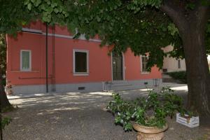 un edificio naranja con un árbol delante de él en Rivaro Palace, en Novi Ligure