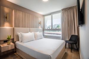 a hotel room with a bed and a window at Astral Palma Hotel in Eilat