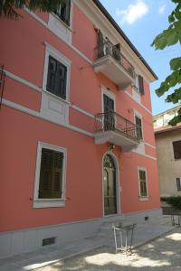 um edifício cor-de-rosa com cadeiras à frente em Rivaro Palace em Novi Ligure