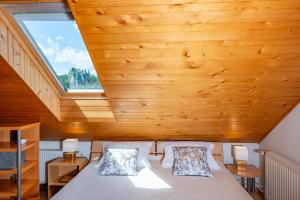 1 dormitorio con 1 cama con techo de madera en DREAMLAND BLED Apartments, en Bled