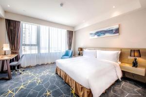 a hotel room with a large bed and a desk at Q-Box Hotel Shanghai Sanjiagang -Offer Pudong International Airport and Disney shuttle in Shanghai