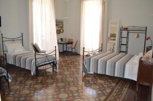 sypialnia z 2 łóżkami, stołem i krzesłami w obiekcie Bed, Book & Breakfast Landolina w Katanii