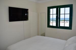 una camera con un letto e una finestra con la spiaggia di Beachfront Bungalow Cotillo Lagos a Cotillo