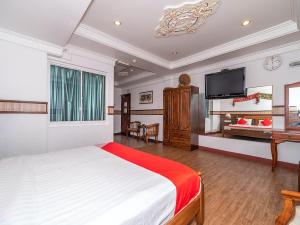 a bedroom with a bed and a flat screen tv at OYO 89864 Hotel Holiday Park in Kota Kinabalu