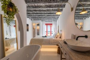 a bathroom with a tub and a bed and a sink at The TownHouse Mykonos in Mýkonos City