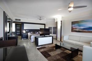 a living room with a couch and a tv and a bed at Hotel Riu Nautilus - Adults Only in Torremolinos