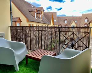 eine Terrasse mit 2 Stühlen und einem Holzzaun in der Unterkunft LE TROIS B in Beaune