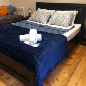 a bed with a blue comforter and towels on it at my house in Tbilisi City