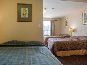 A bed or beds in a room at Hotel Richmond Hill Inn ON North