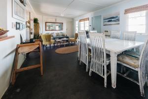 a dining room and living room with a table and chairs at Umzumbe Surf House in Umzumbe