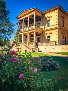 a large house with flowers in front of it at Vila Lanna in Prague