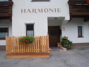 a white building with a wooden fence in front of it at Appartement Harmonie in Sölden